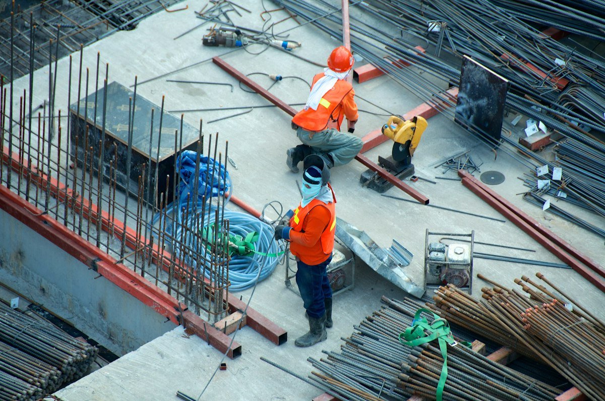 Personal de obra trabajando sobre una losa con varillas de acero